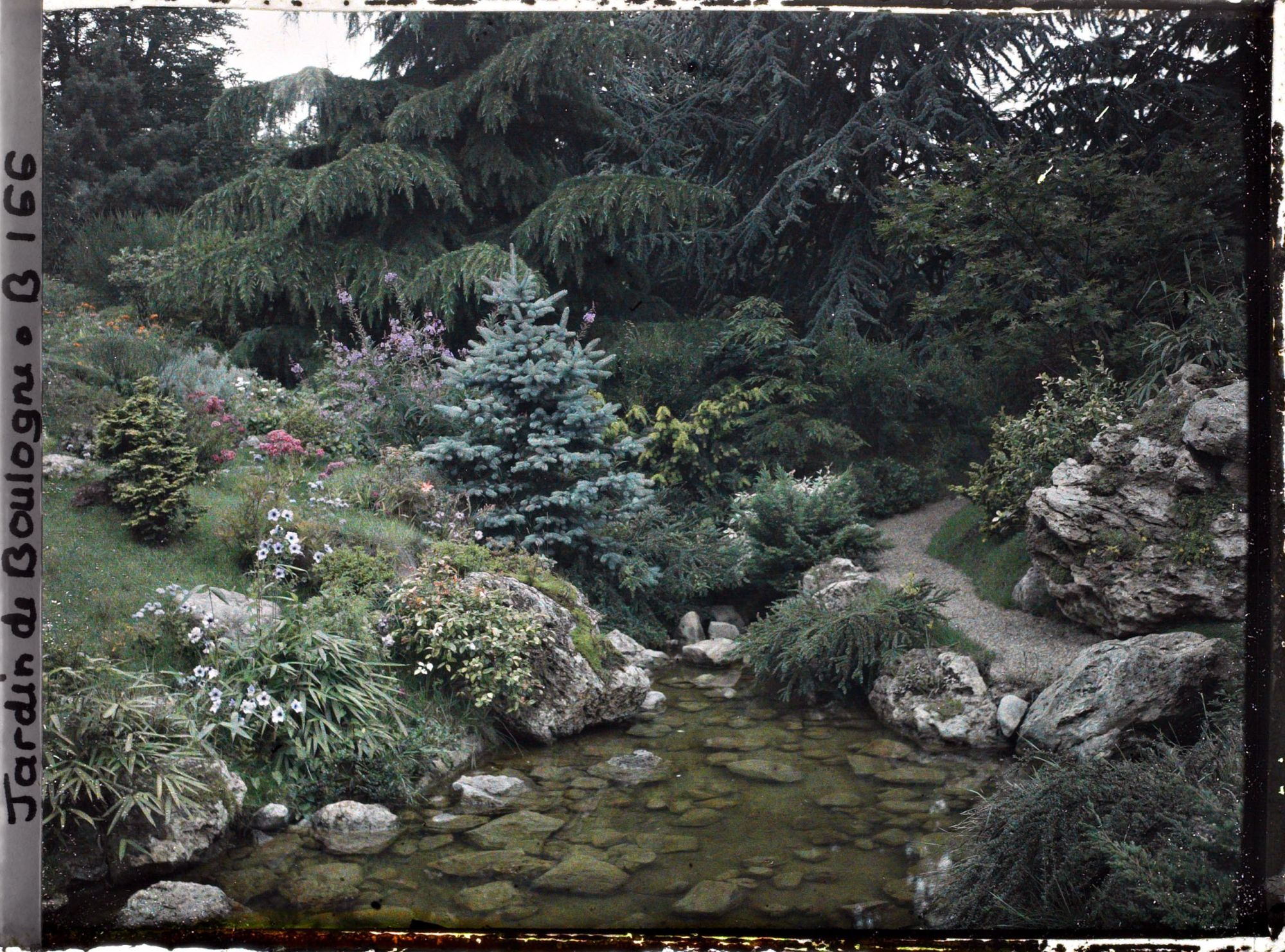 Image représentant Cours d'eau du " sanctuaire japonais " entre une rive fleurie et un chemin bordé de roches