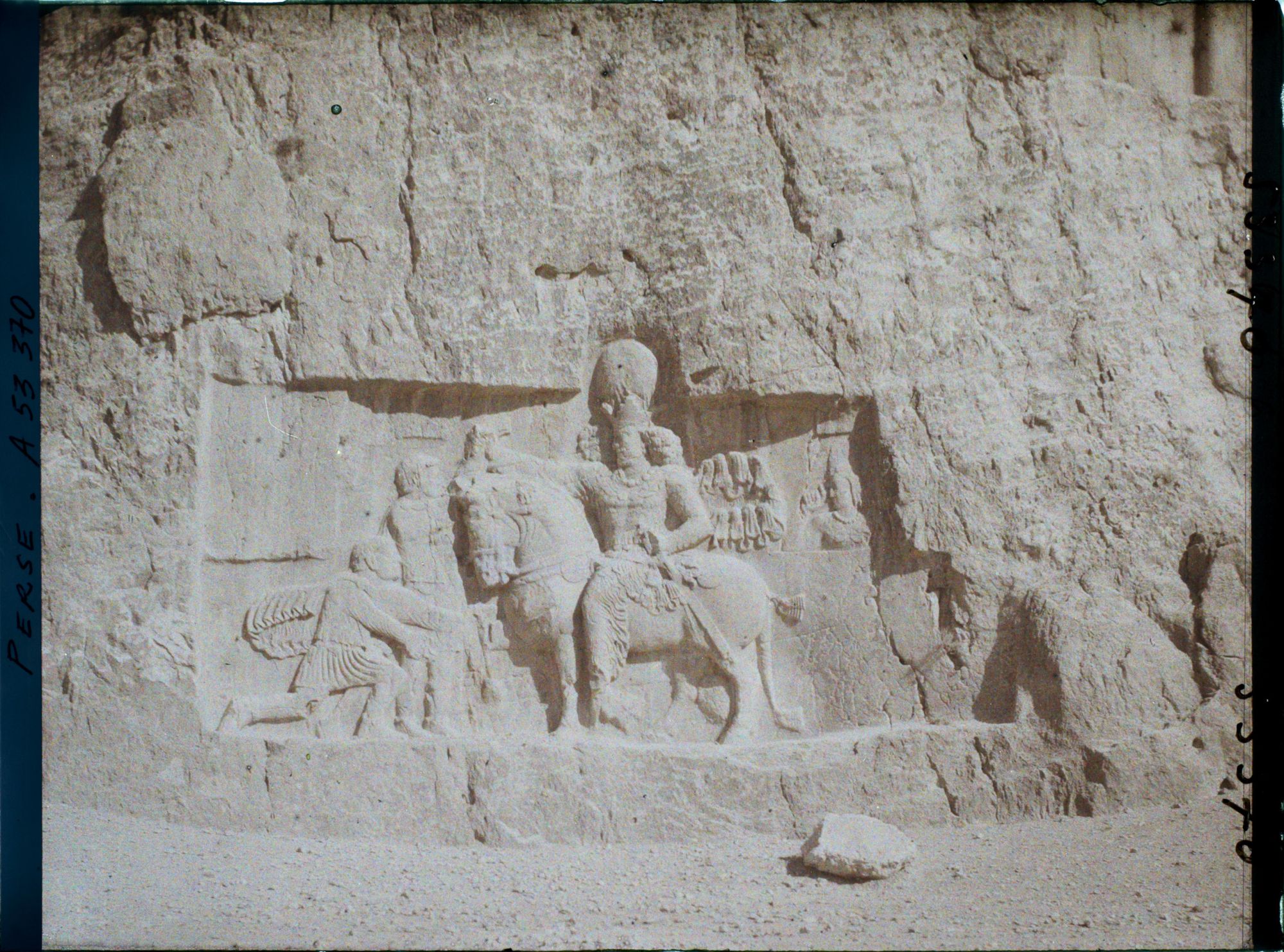 Image représentant Bas-relief sassanide sous le tombeau de Darius. Scène de triomphe de Shapur 1er sur Philippe L'Arabe, agenouillé et sur l'empereur romain Valérien qui remet ses armes au vainqueur monté sur son cheval (fin IIIe siècle)