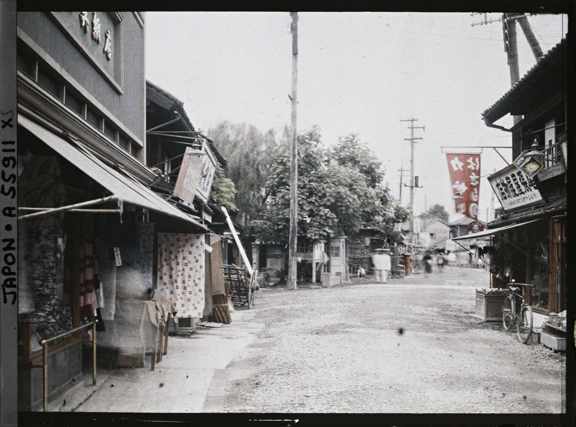 Image représentant Une rue du quartier d'Akasaka (?), au premier plan, une boutique de tissus, à droite, un marchand de chaussures