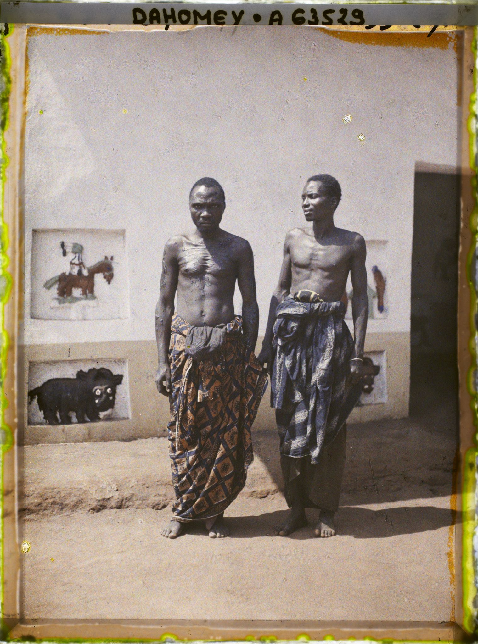 Image représentant Les deux artistes restaurateurs des reliefs des palais, devant l'ajalala (bâtiment de réception) de  null Guézo