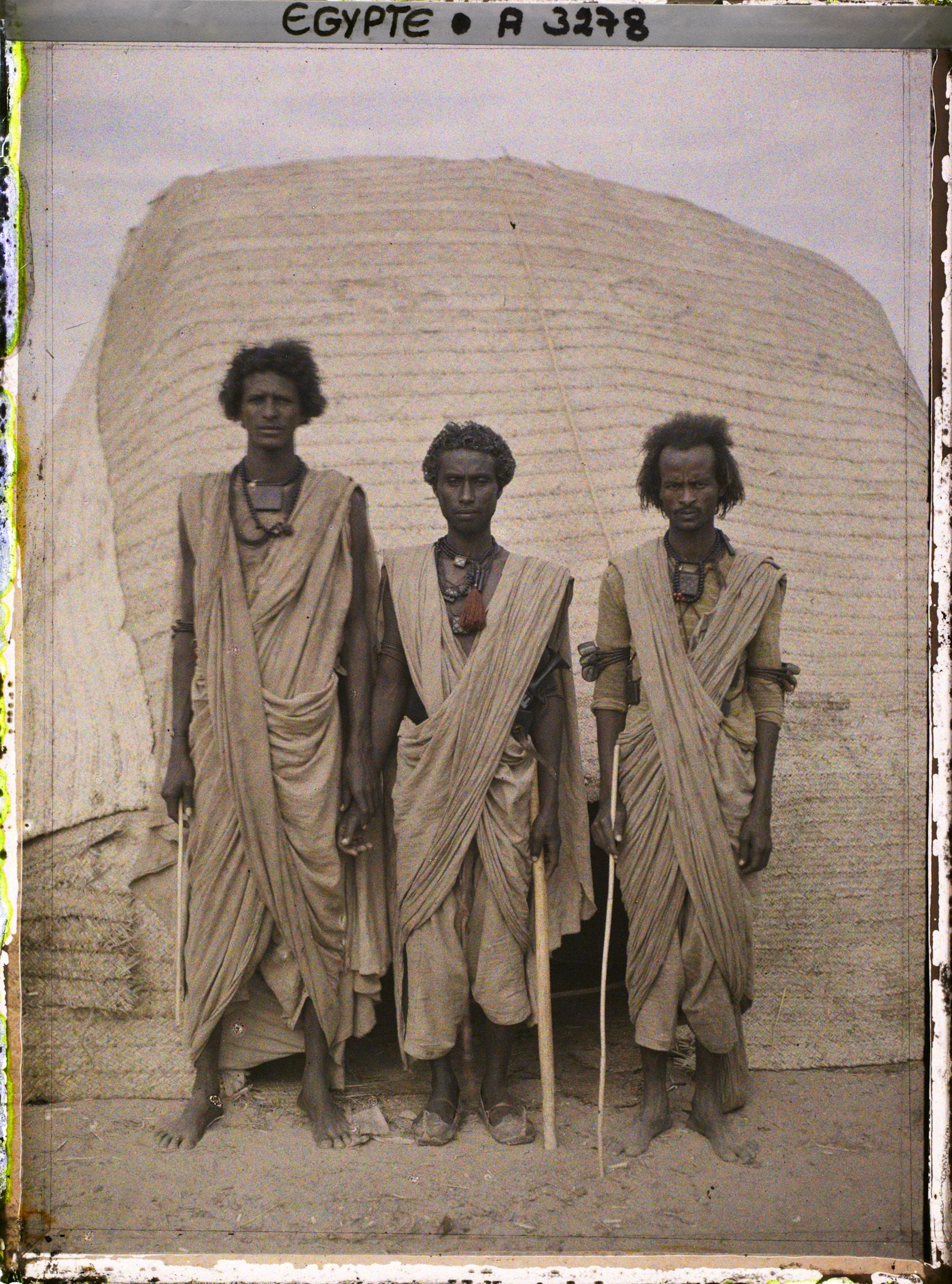 Image représentant Trois hommes  null bishari posant devant une habitation