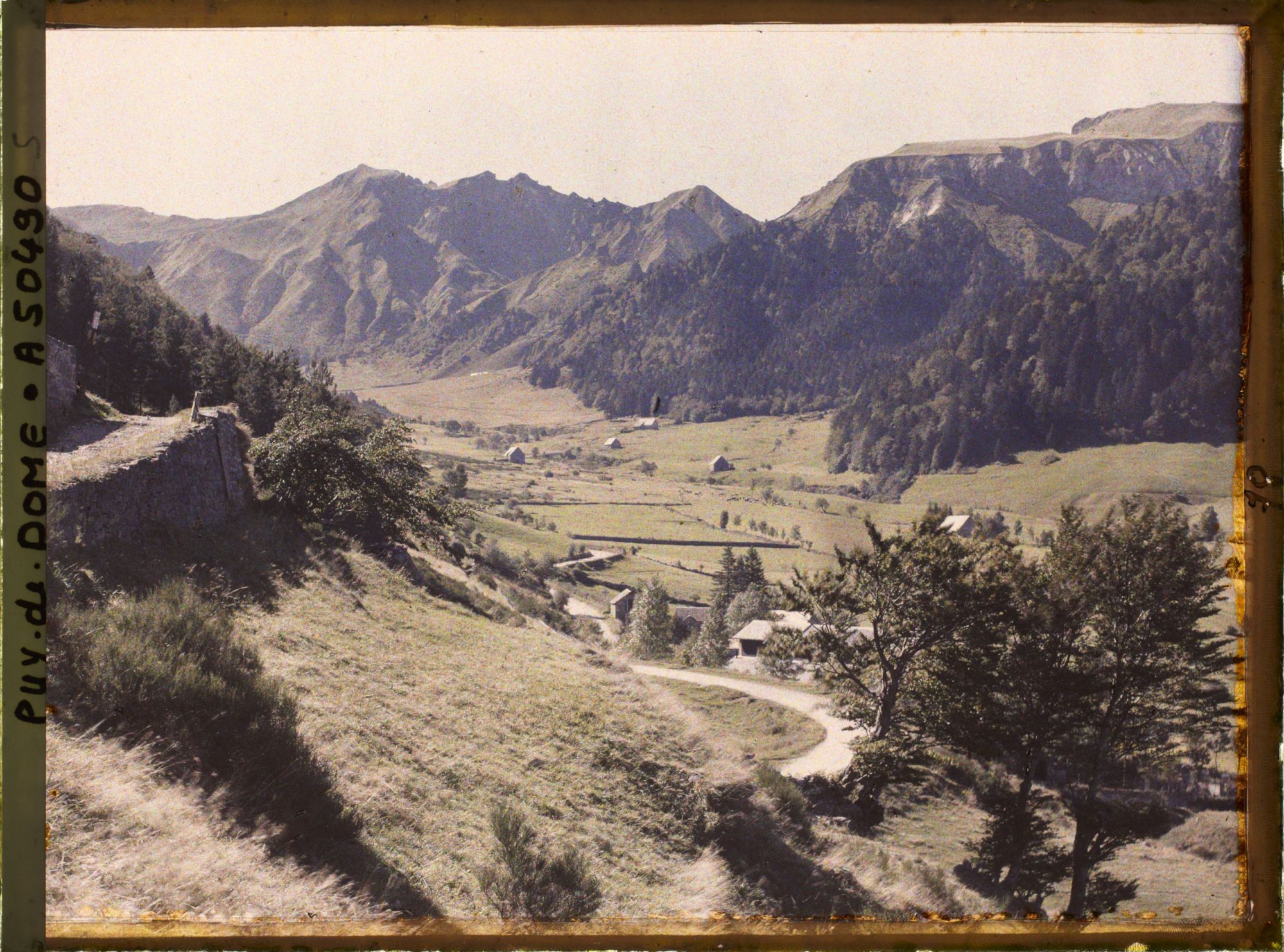 Image représentant France, Mont-Dore, Le fond de la Vallée et les Burons et la route de Besse ; au fond, le Sancy