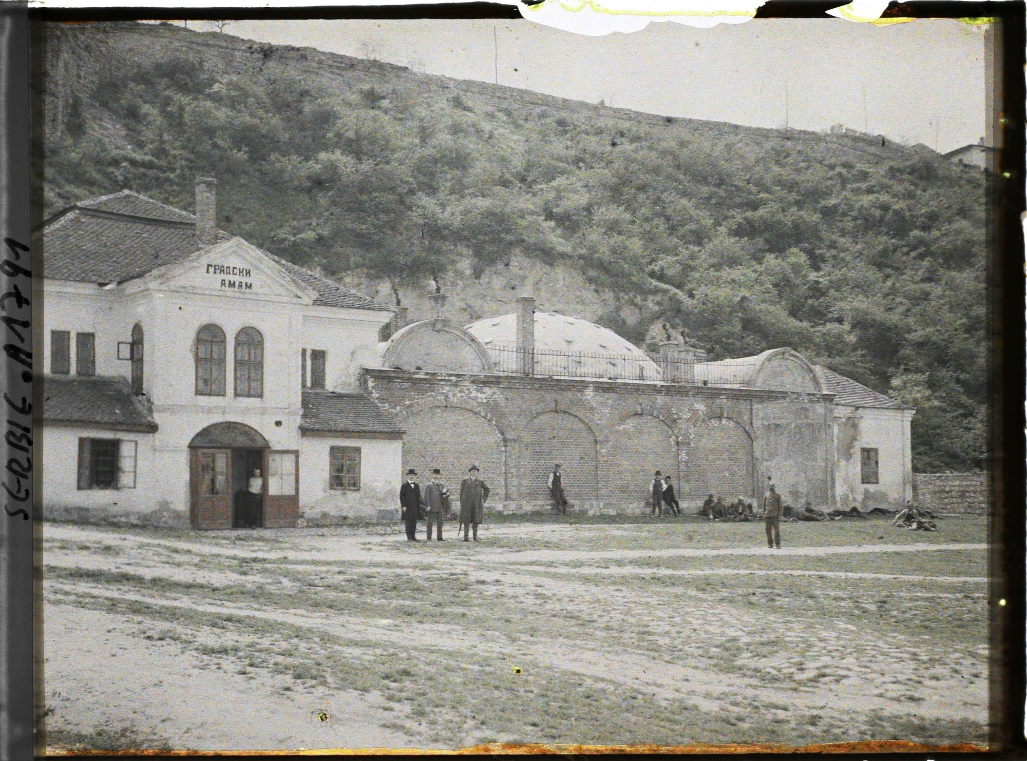 Image représentant Jean Brunhes entre deux hommes, devant le bain municipal