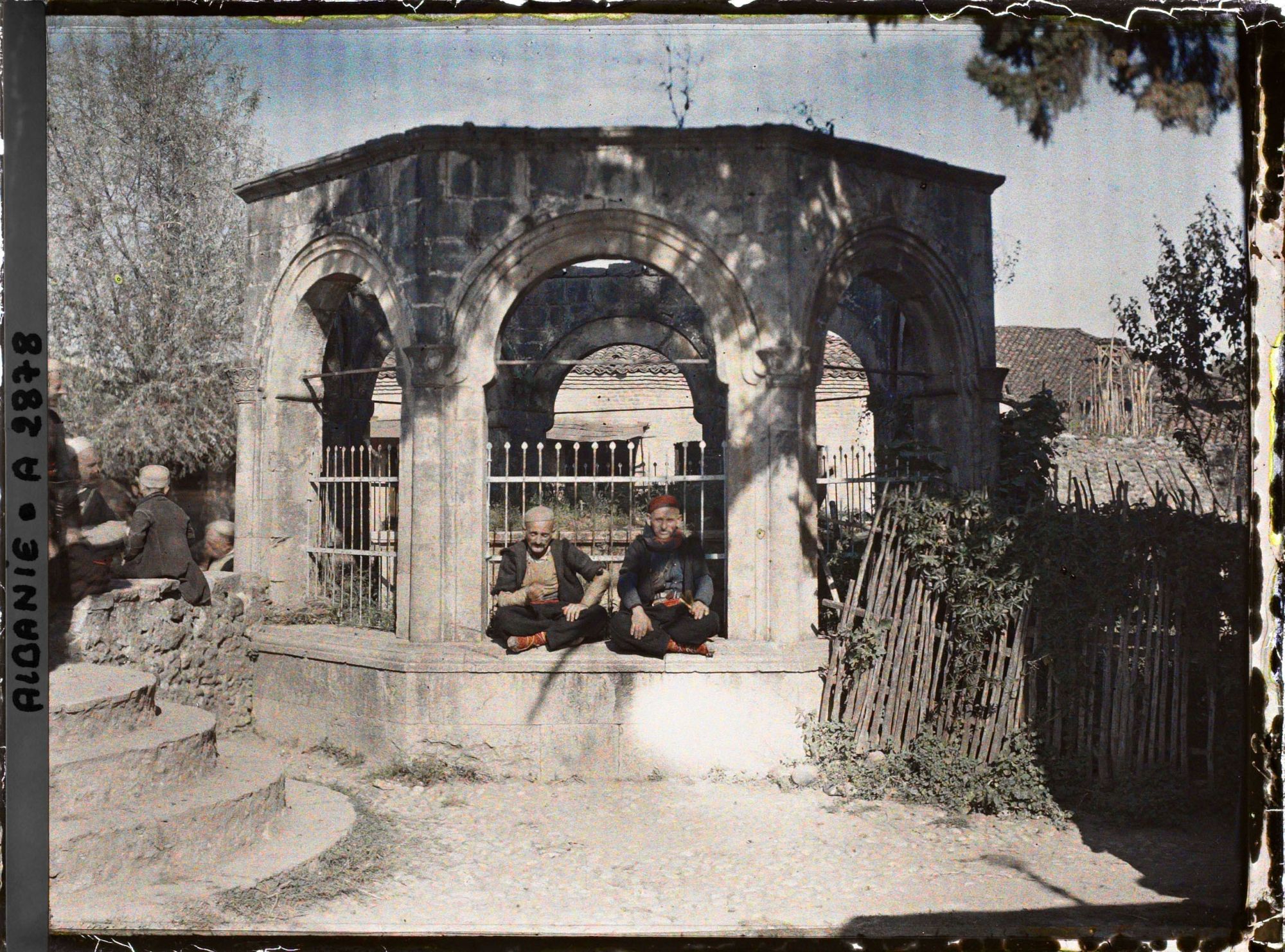 Image représentant Deux hommes assis sous les arcades du türbe (mausolée) d'un pacha de Scutari