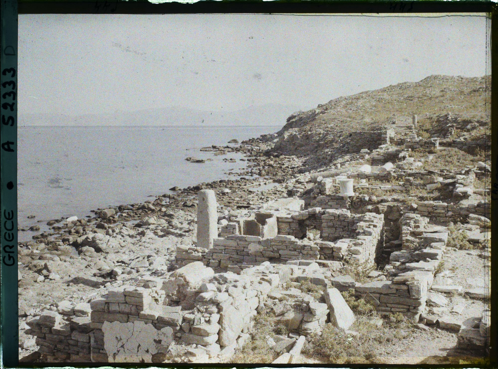 Image représentant Ruines d'habitations. Au fond, l'Ile de Tinos