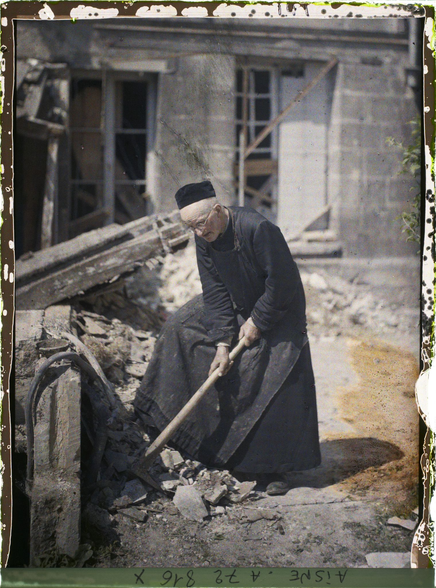 Image représentant L'abbé Hivet, curé de Saint-Waast, 86 ans, resté à Soissons, déblayant des gravats