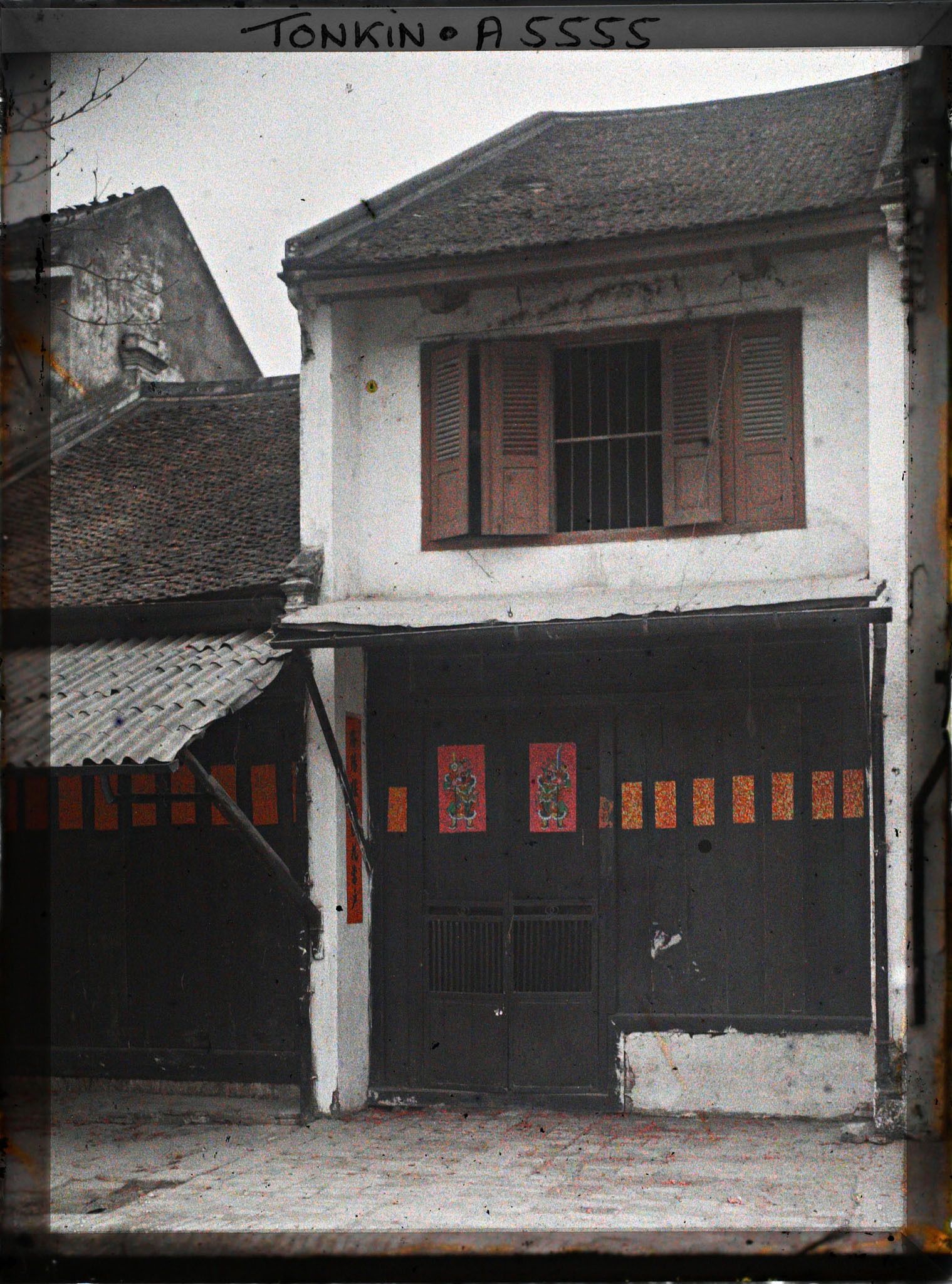 Image représentant La façade d'une maison aisée, décorée d'images peintes, au moment de la fête du Têt