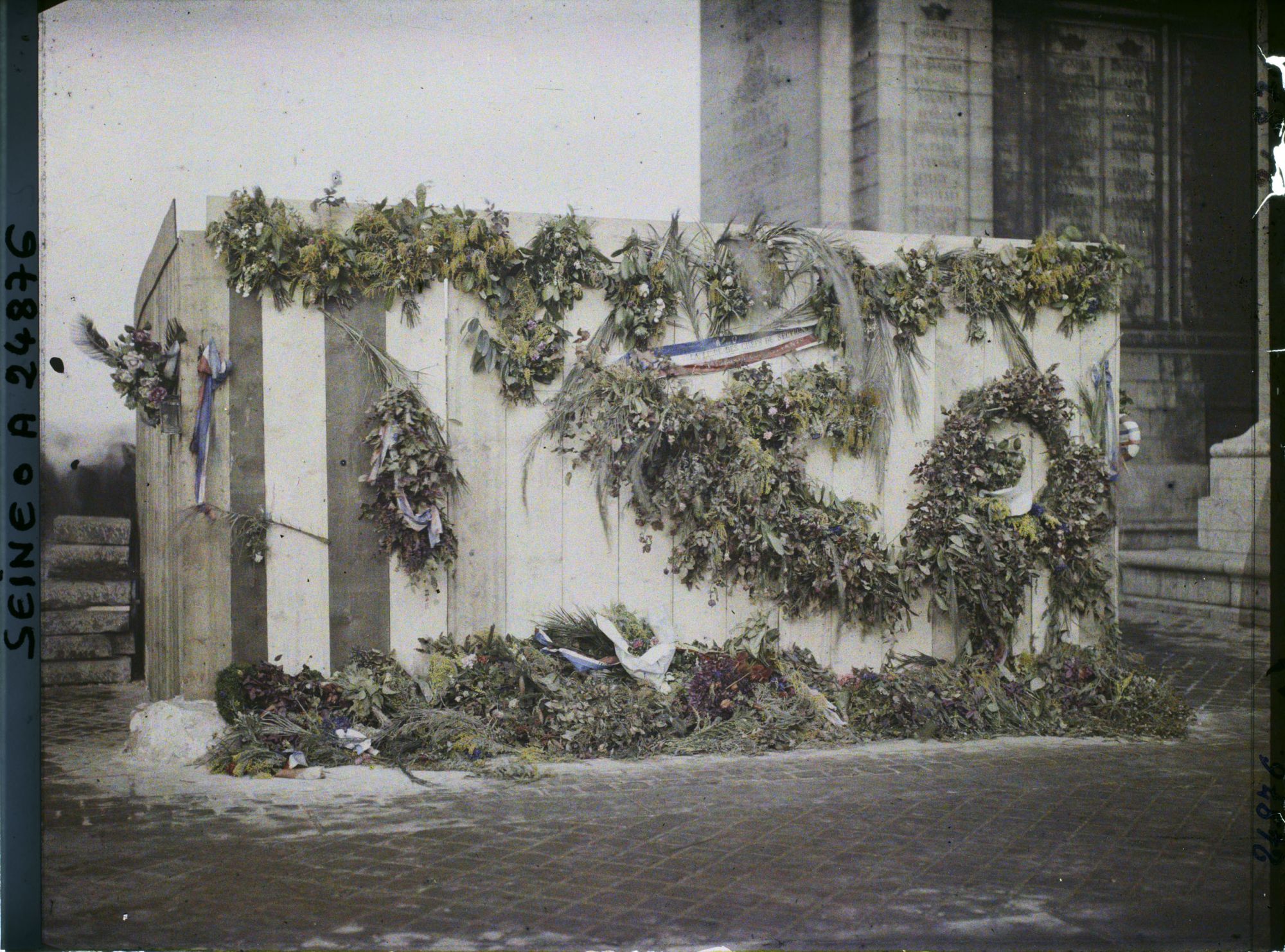 Image représentant Palissade recouverte de fleurs à l'endroit où sera inhumé le 28 janvier 1921 le soldat inconnu, sous l'Arc de Triomphe