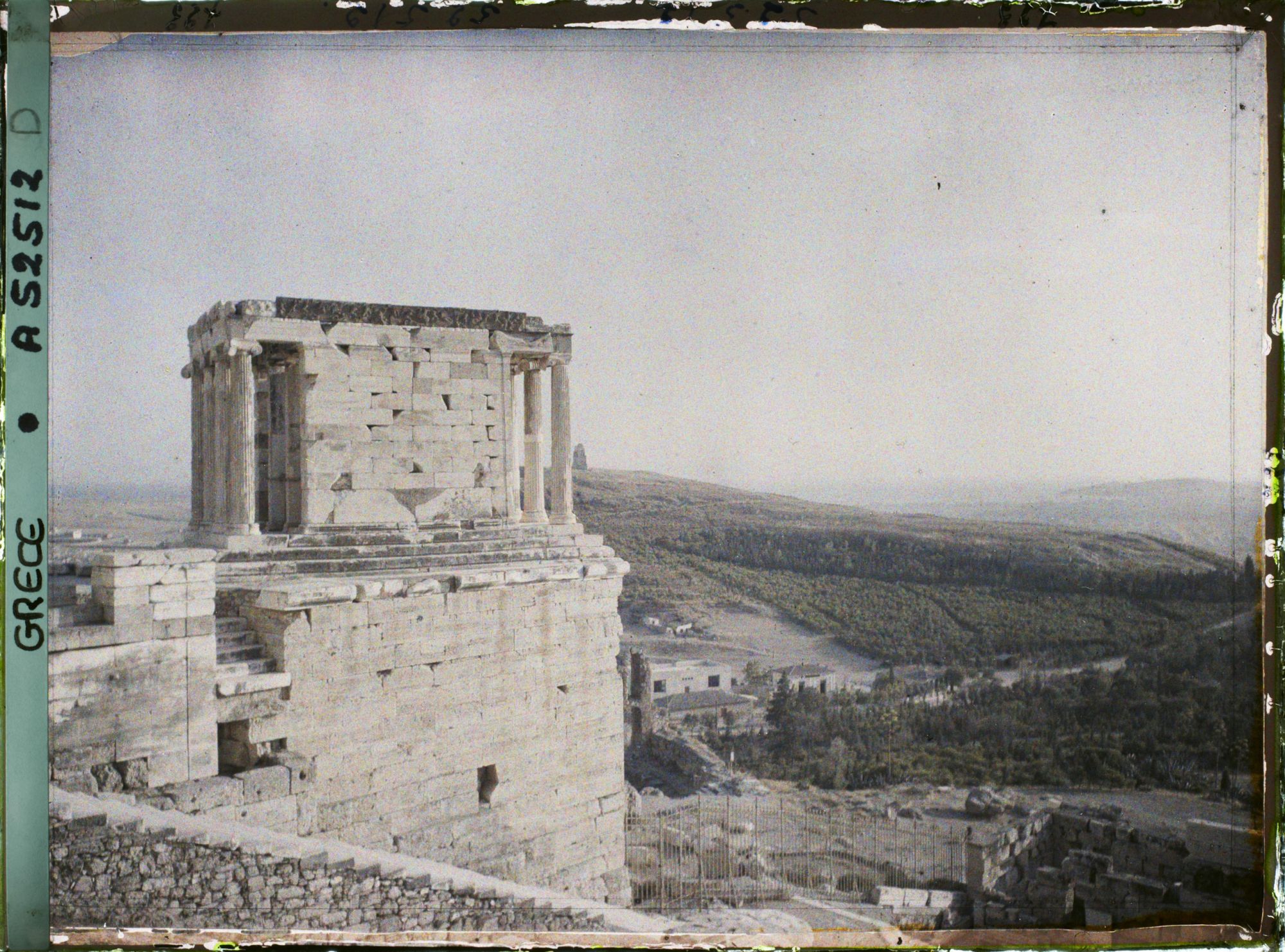 Image représentant L'extrémité ouest de l'Acropole et les escaliers y menant au premier plan, et le Temple d'Athéna Nike (profil nord)
