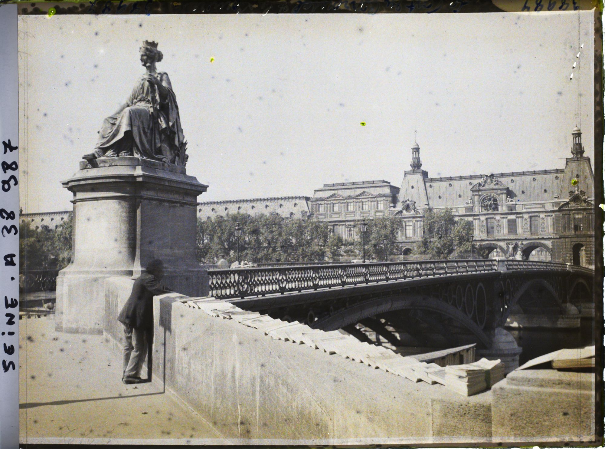 Image représentant Un bouquiniste sur le pont du Carrousel, le Louvre en arrière-plan