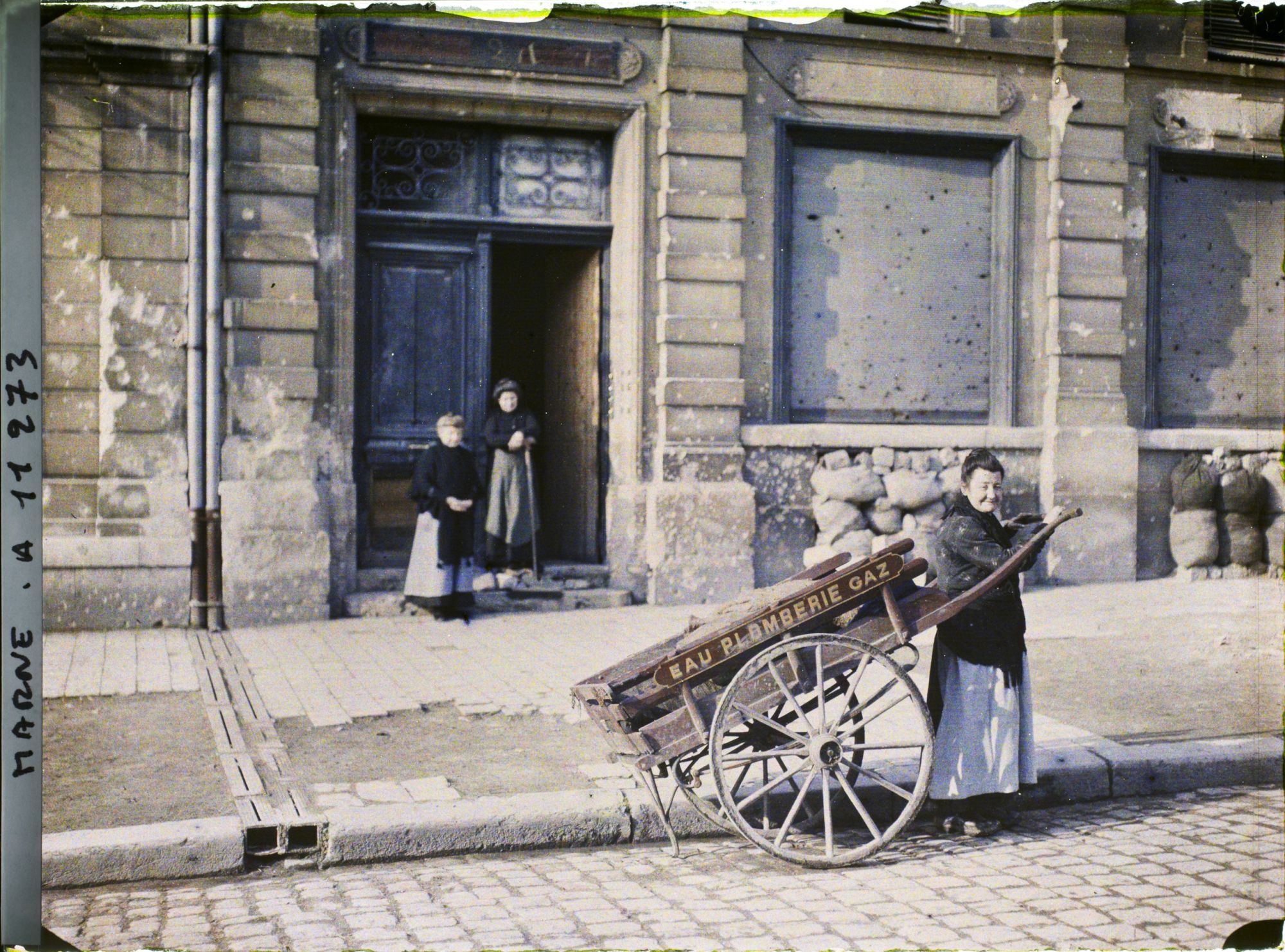 Image représentant Femme avec une charreton (charrette) devant une habitation, rue Libergier