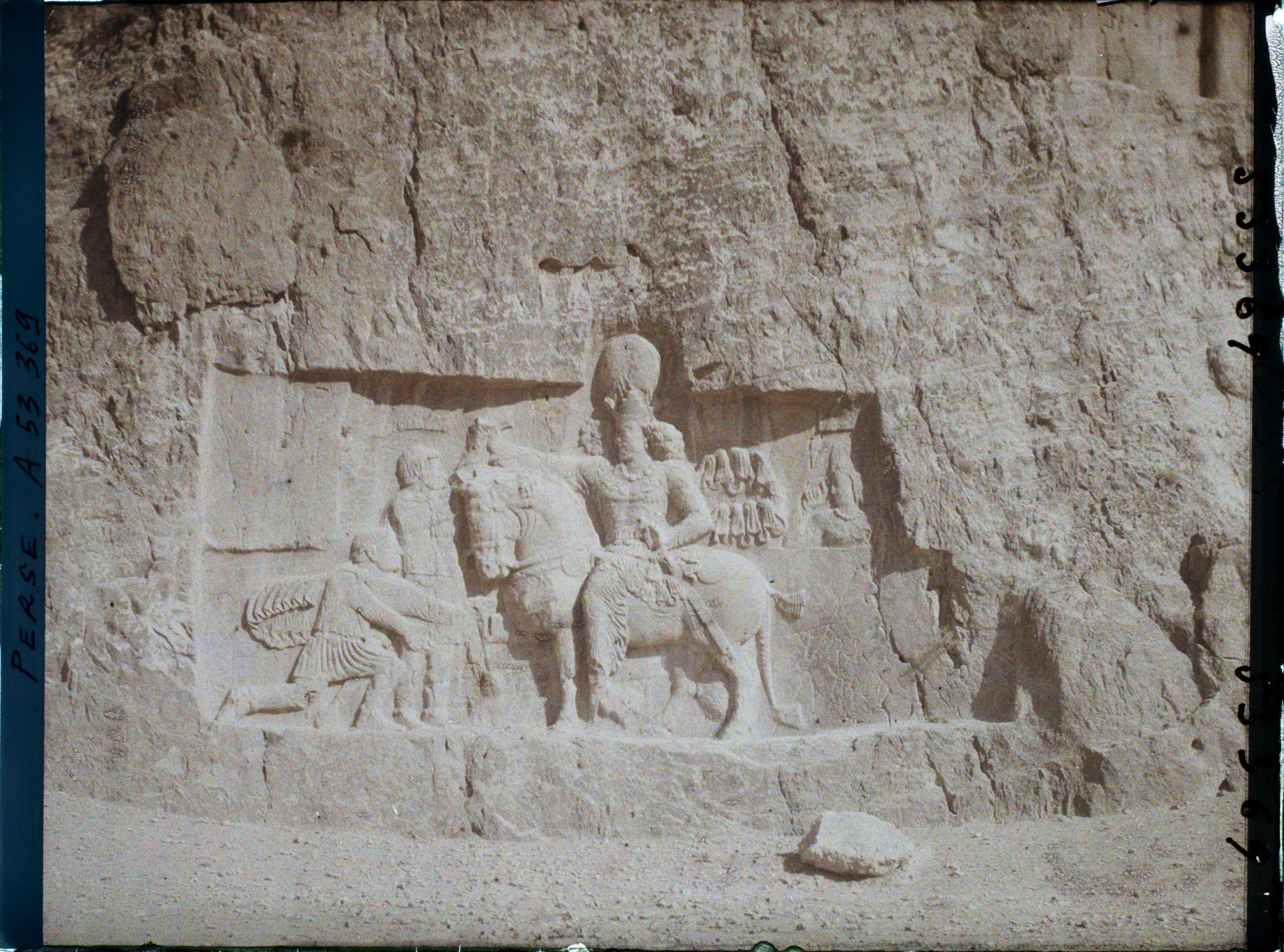 Image représentant Bas-relief sassanide sous le tombeau de Darius. Scène de triomphe de Shapur 1er sur Philippe L'Arabe, agenouillé et sur l'empereur romain Valérien qui remet ses armes au vainqueur monté sur son cheval (fin IIIe siècle)