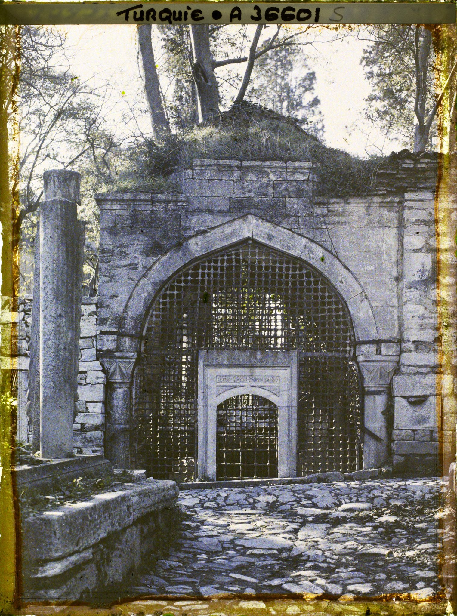 Image représentant Porte d'un mausolée : porte grillagée sur une allée pavée permettant d'accéder à une cour derrière l'Eyüp Sultan Camii