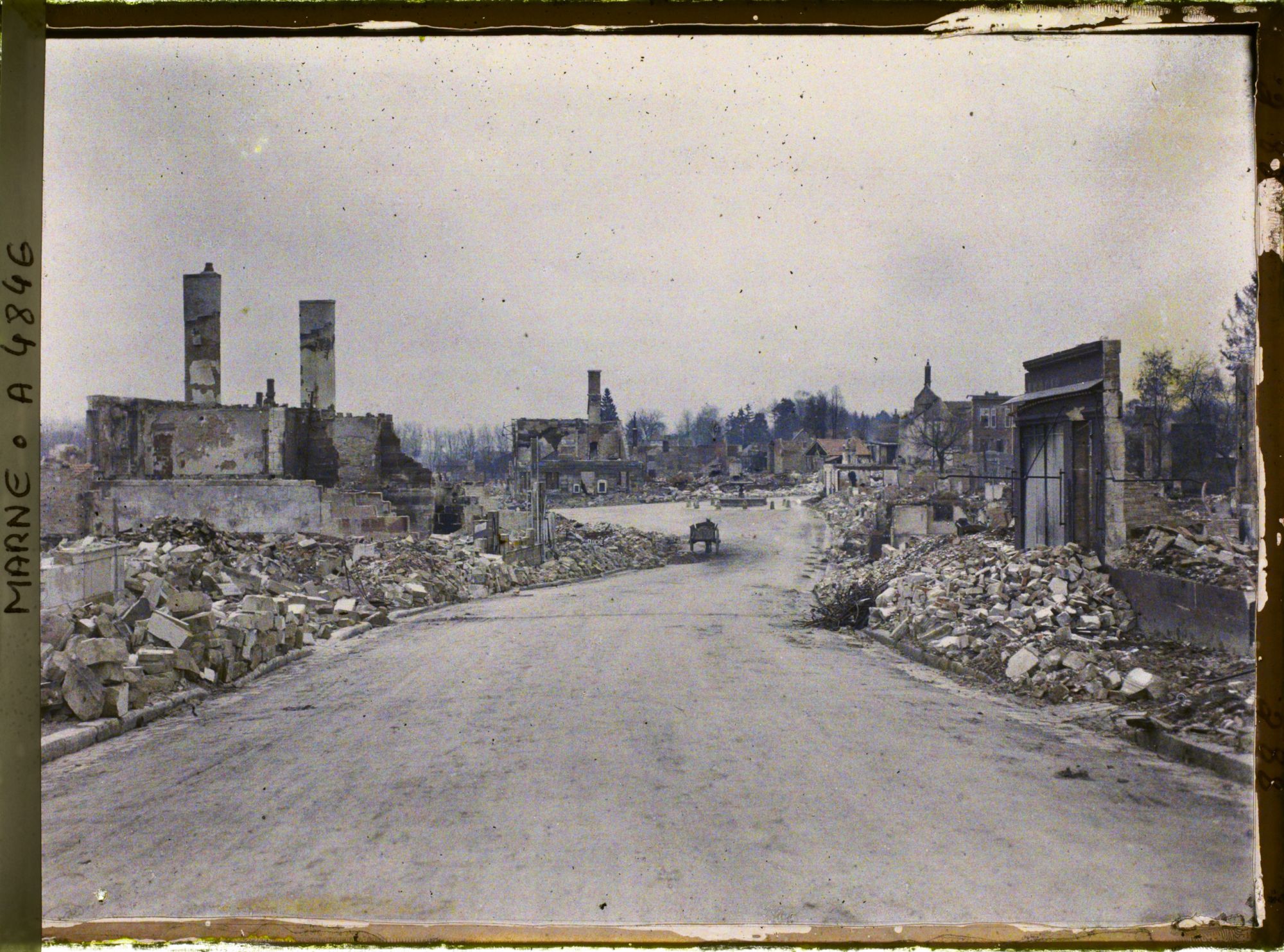 Image représentant La rue de Vitry en ruine avec au fond la fontaine de la place de l'Hôtel de ville