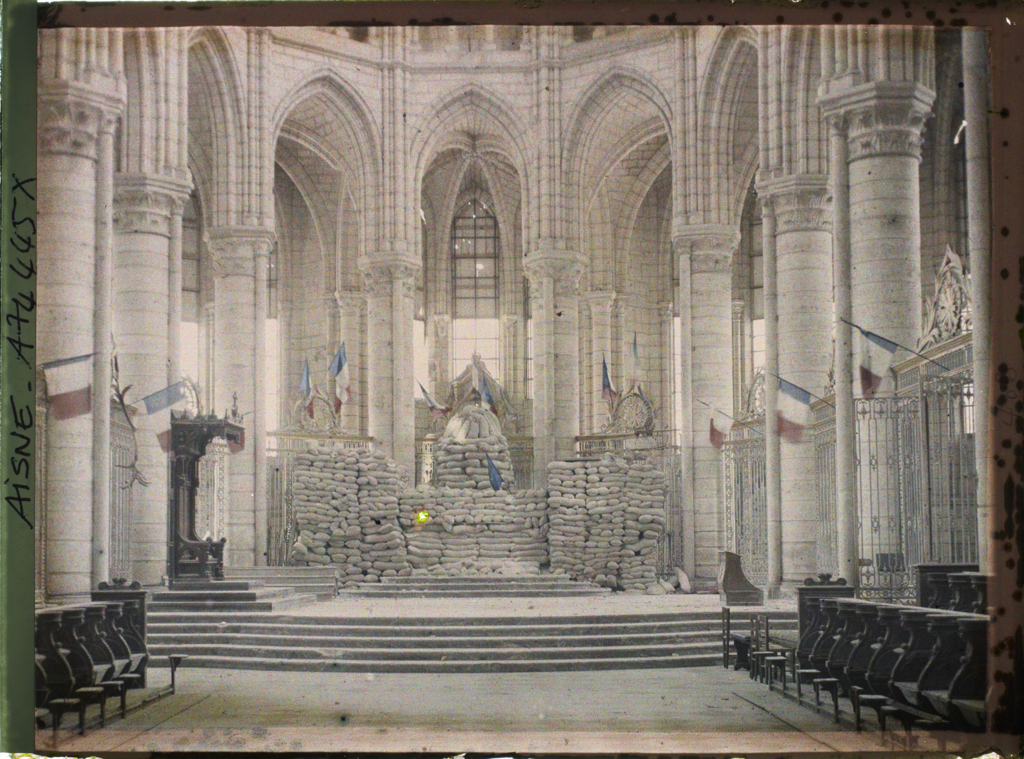Image représentant Intérieur de la cathédrale, l'autel protégé par des sacs de sable et les drapeaux français accrochés aux piliers