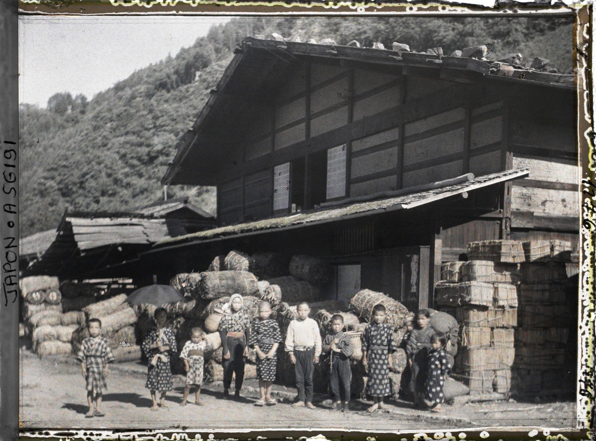 Image représentant Groupe d'enfants devant la maison d'un marchand de charbon et de bardeaux