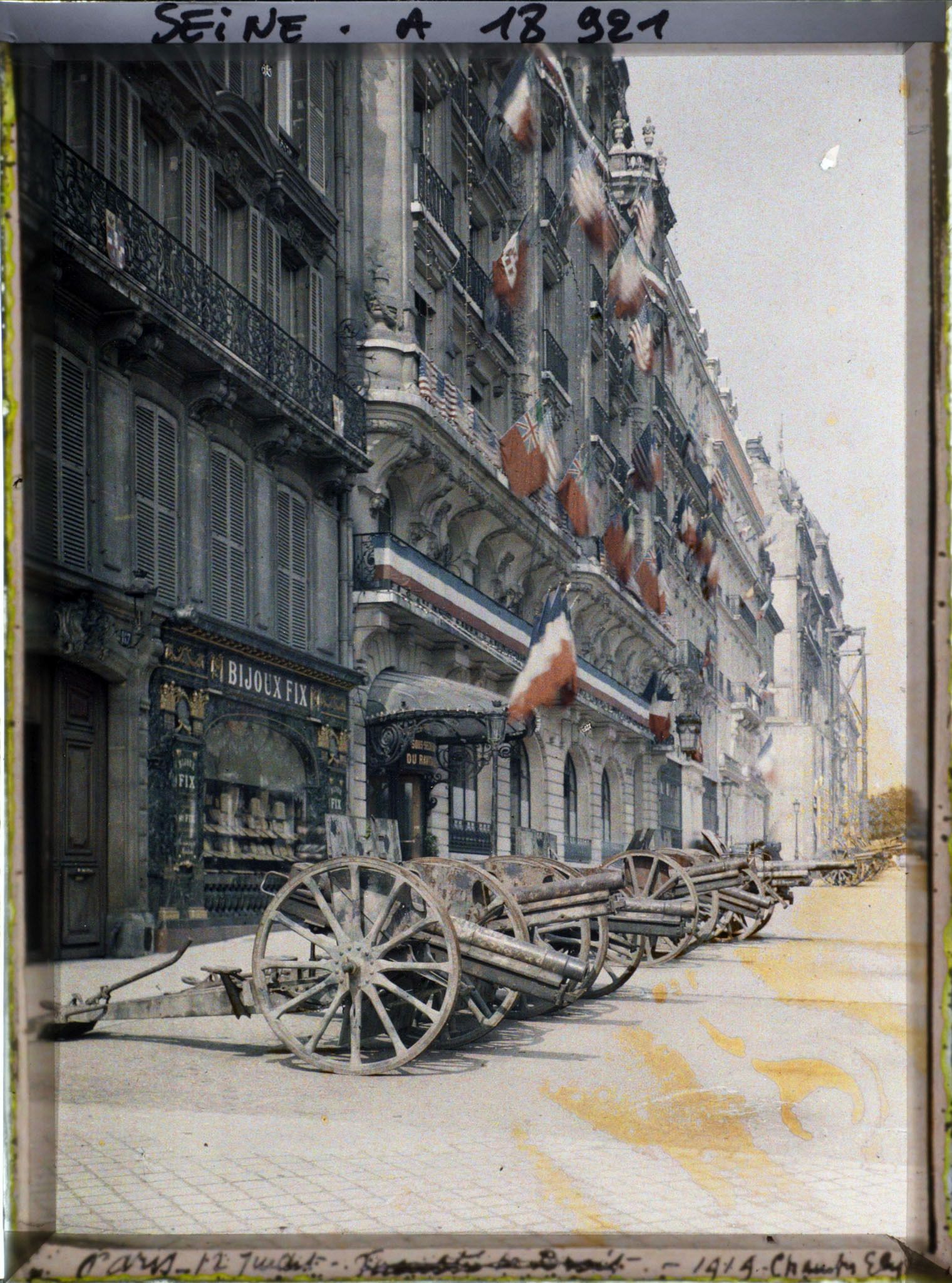 Image représentant Canons exposés sur l'avenue des Champs-Elysées et hôtel Carlton décoré de drapeaux pour les fêtes de la Victoire des 13 et 14 juillet 1919