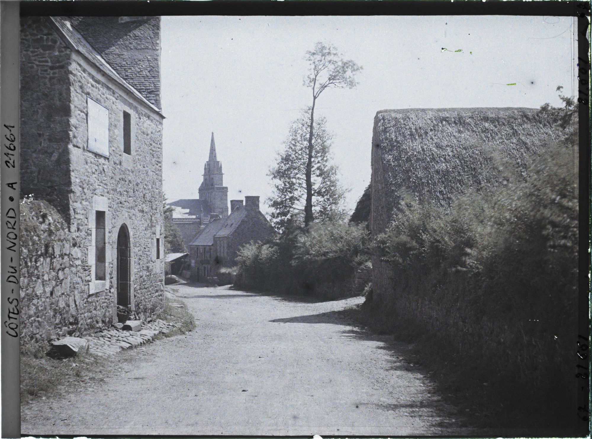 Image représentant L'entrée du village, avec à l'arrière-plan l'église Saint-Yves