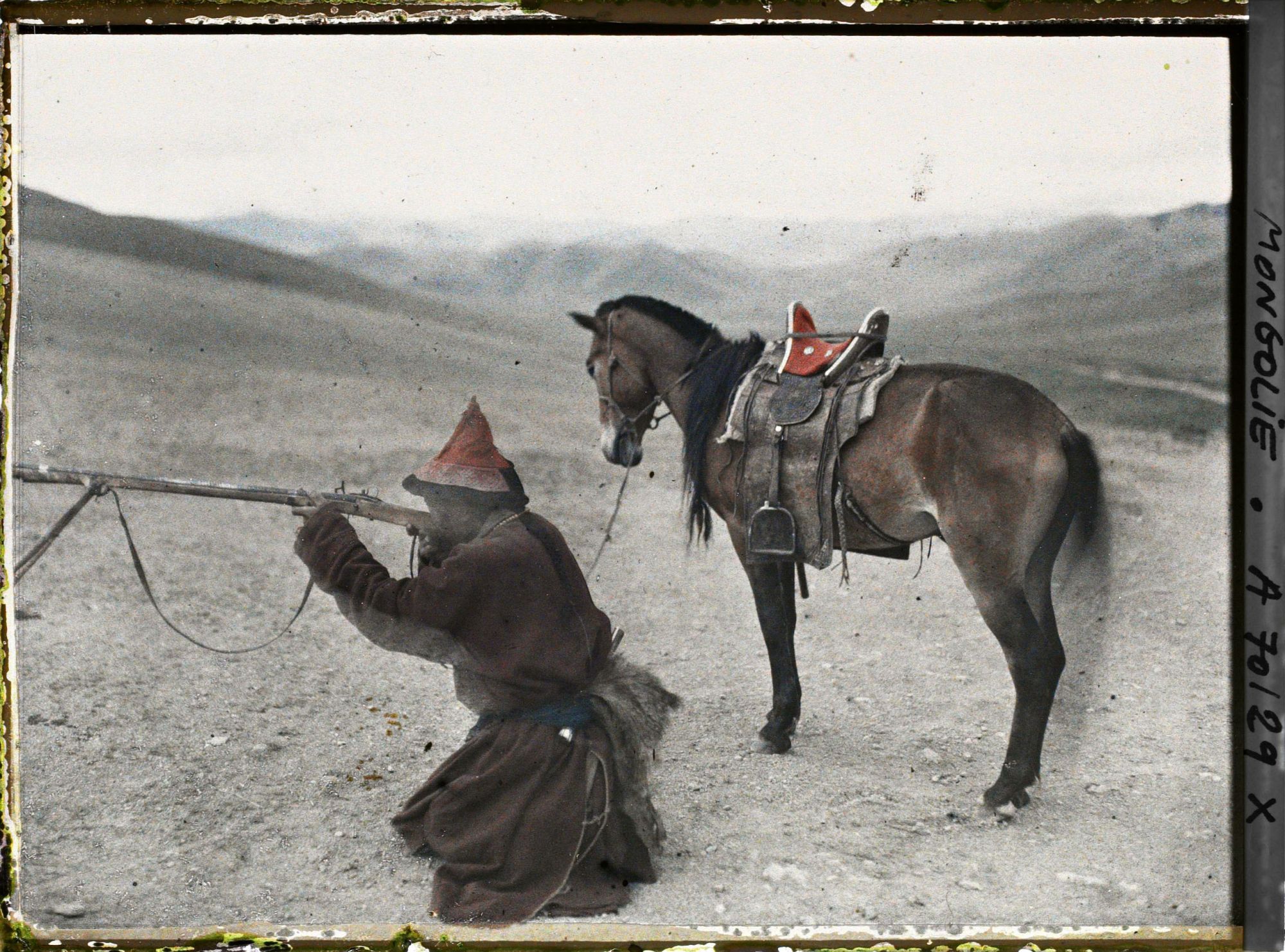 Image représentant Chasseur mongol descendu de cheval faisant une démonstration du maniement du fusil à pierre