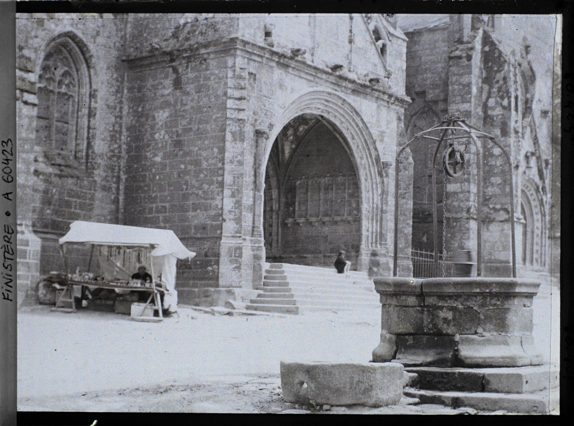 Image représentant Le portail de l'église Saint-Ronan et le vieux puits sur la place de l'Eglise