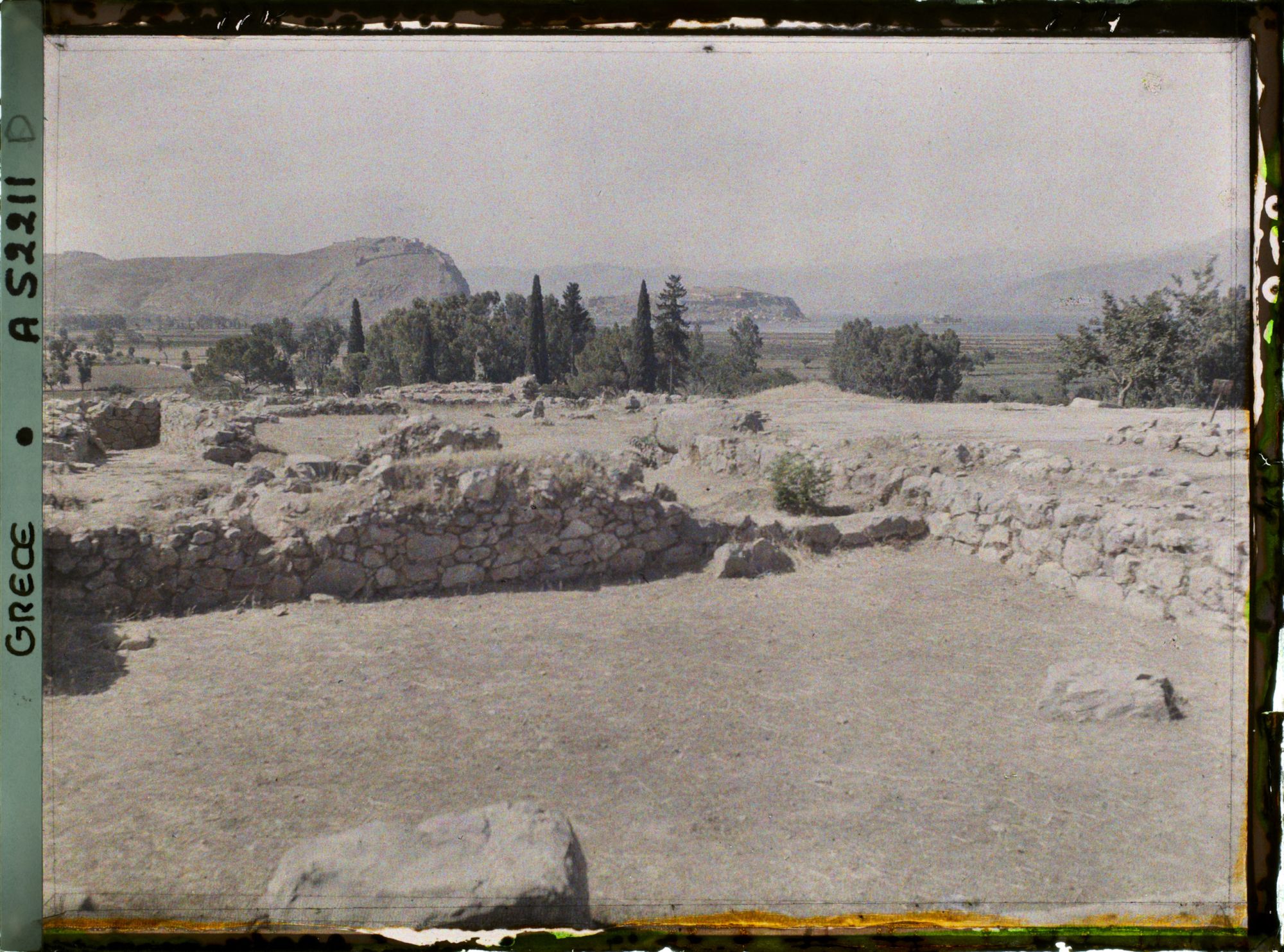 Image représentant Palais Royal, dans la citadelle. Vue prise du Megaron (foyer seigneurial) vers la cour (en direction du sud). Au fond, Nauplie et son rocher