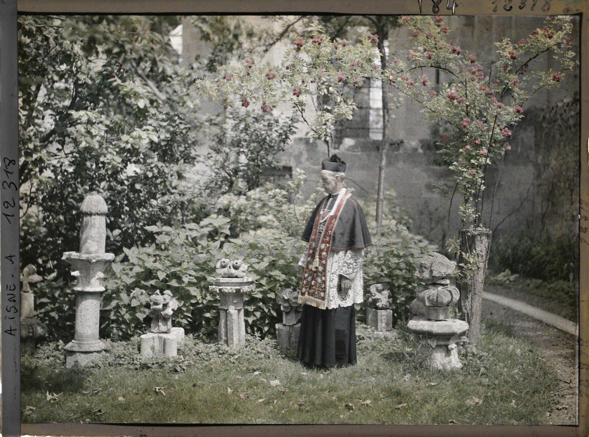 Image représentant Monseigneur Landais, archiprêtre de la cathédrale, devant des fragments de statues