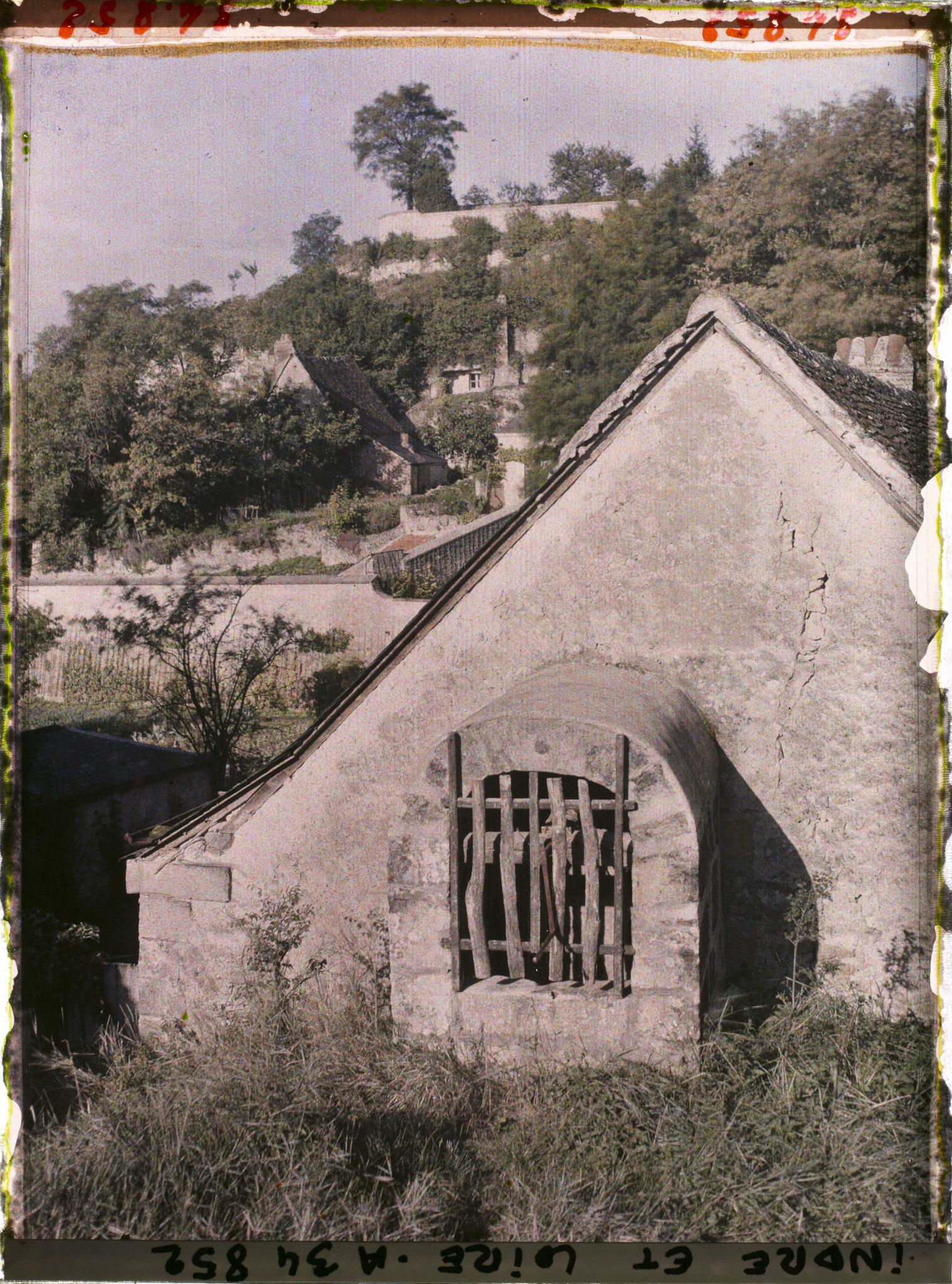 Image représentant Puits près du toit d'un maison, au fond les habitations troglodyte
