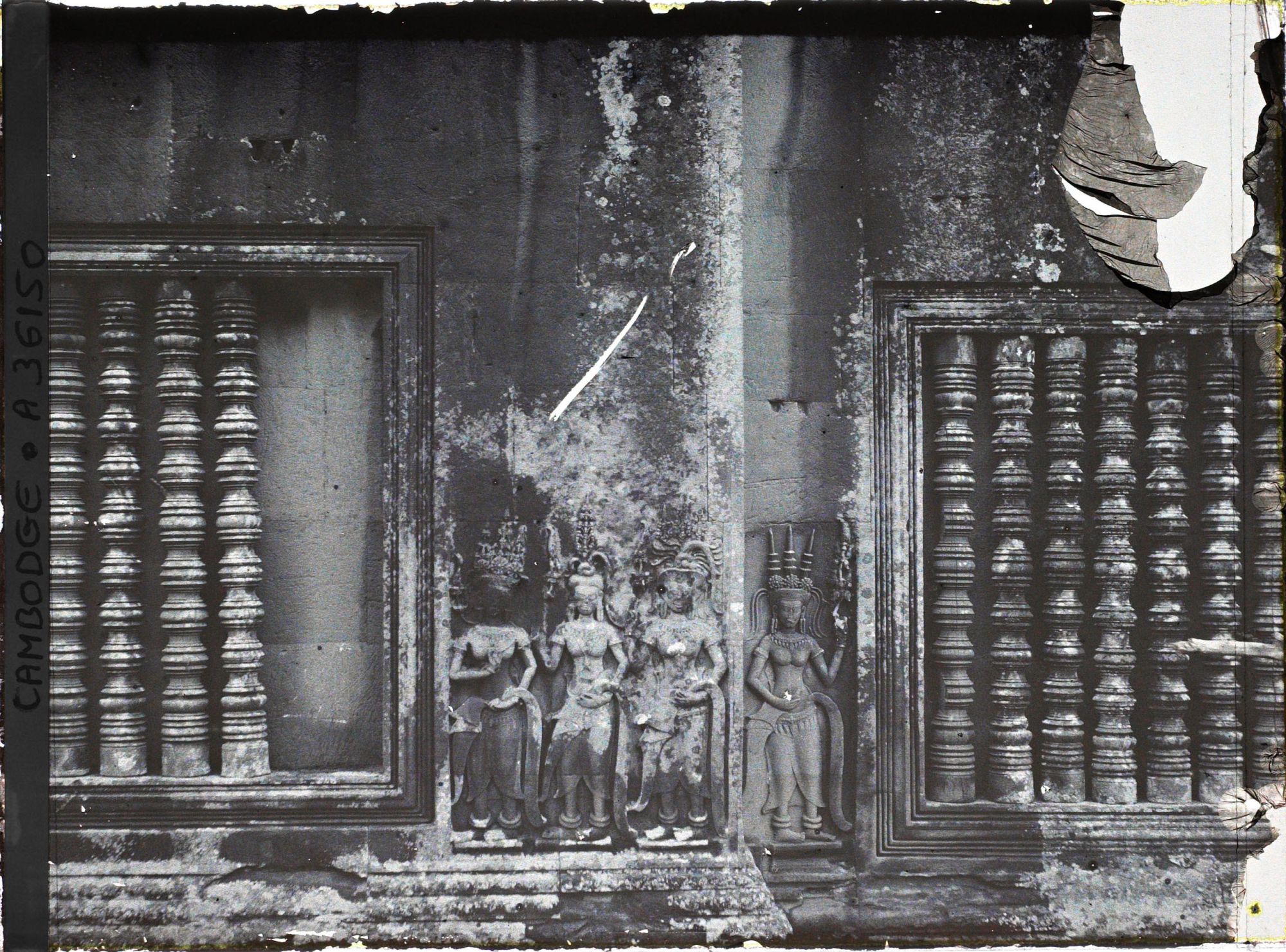 Image représentant Un relief d'apsaras sculpté entre deux fenêtres à balustres d'une galerie