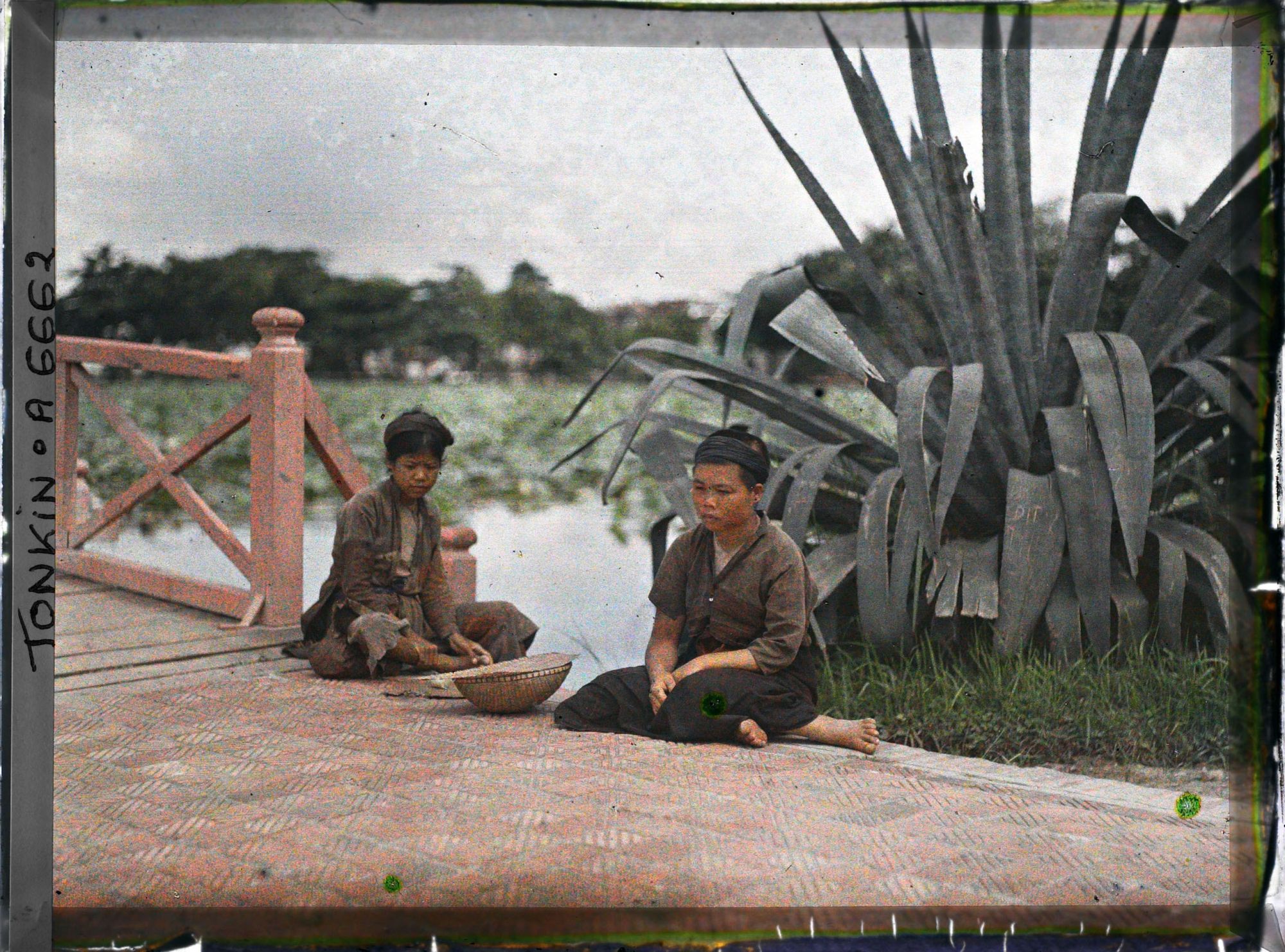 Image représentant Deux mendiantes assises au pied d'un agave, à l'entrée de la passerelle conduisant au temple Ngoc-so'n (appelé par les Européens "Pagode des Pinceaux")