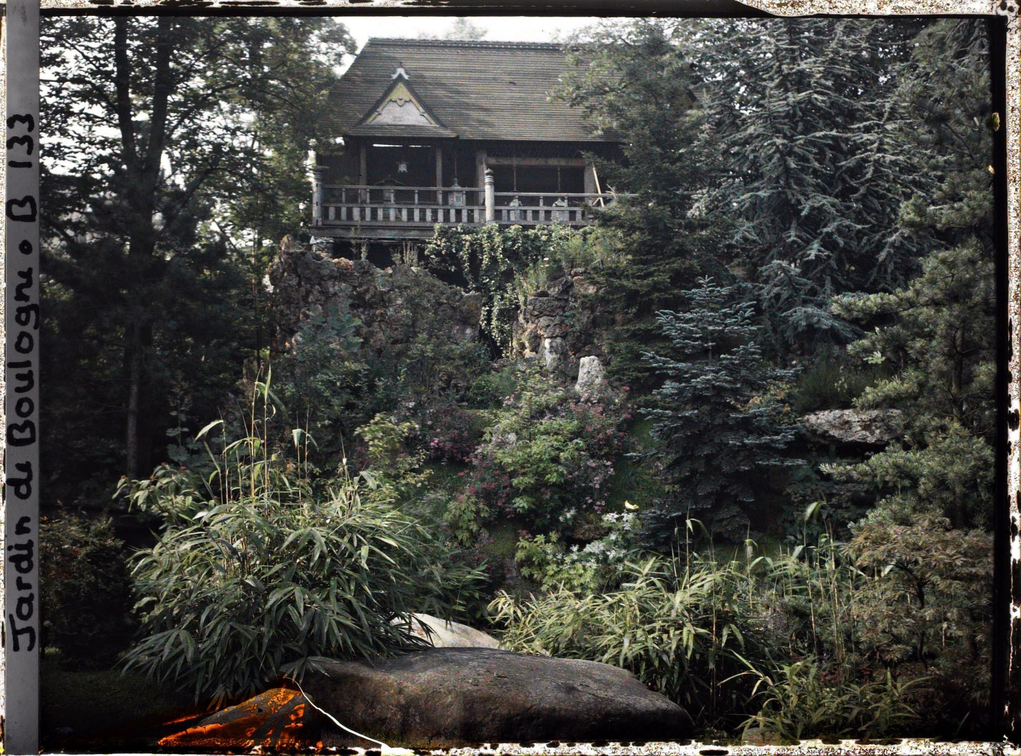 Image représentant Façade de temple dominant le " sanctuaire japonais " partiellement masqué par la végétation arborée
