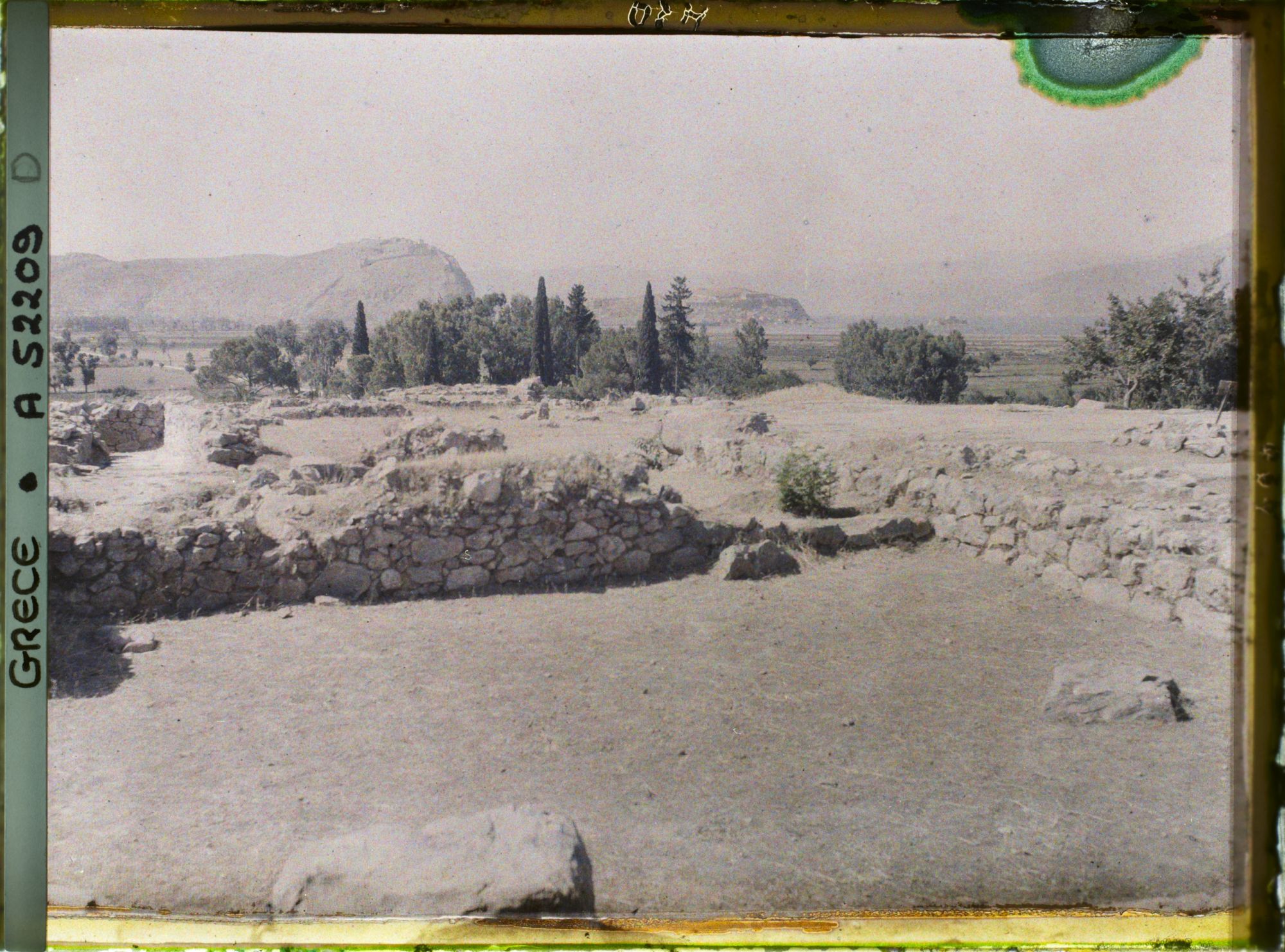 Image représentant Palais Royal, dans la citadelle. Vue prise du Megaron (foyer seigneurial) vers la cour (en direction du sud). Au fond, Nauplie et son rocher