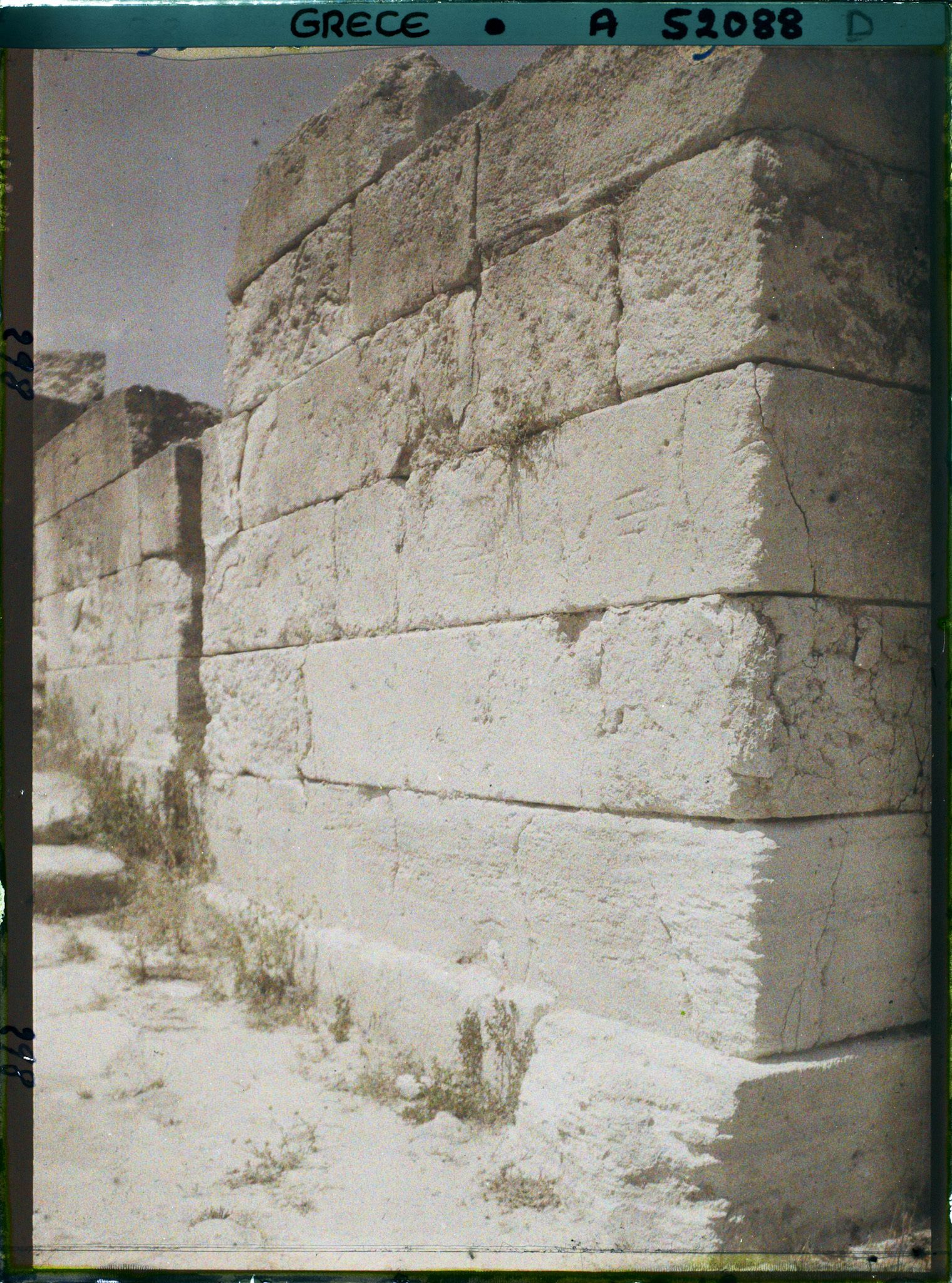 Image représentant Un mur du Palais (bordant sans doute la cour occidentale). Une pierre d'angle est gravée de tridents