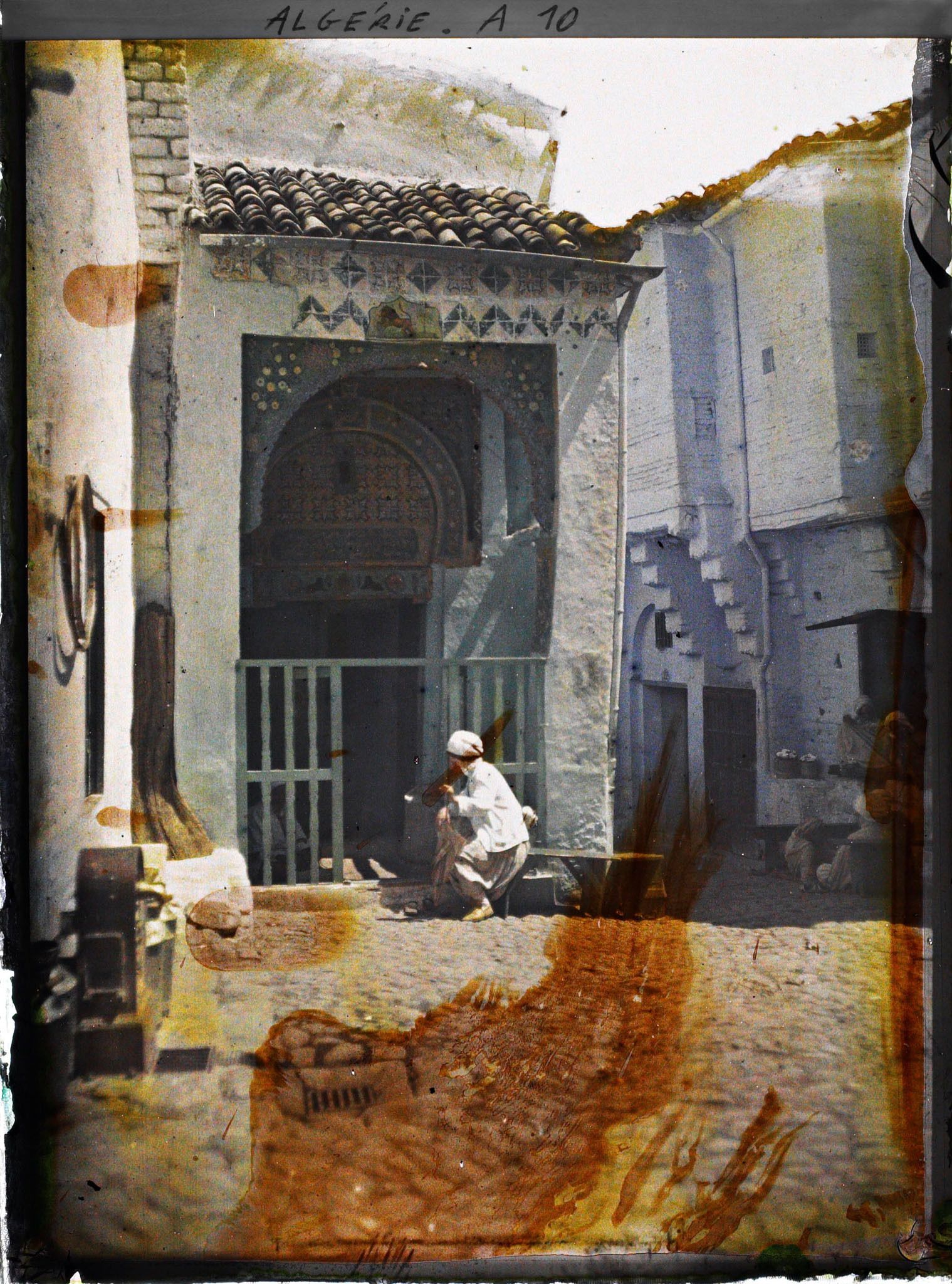 Image représentant Un homme assis sur un banc à l'entrée de la zaouia de Sidi Abd el-Moumen, rue des Tanneurs