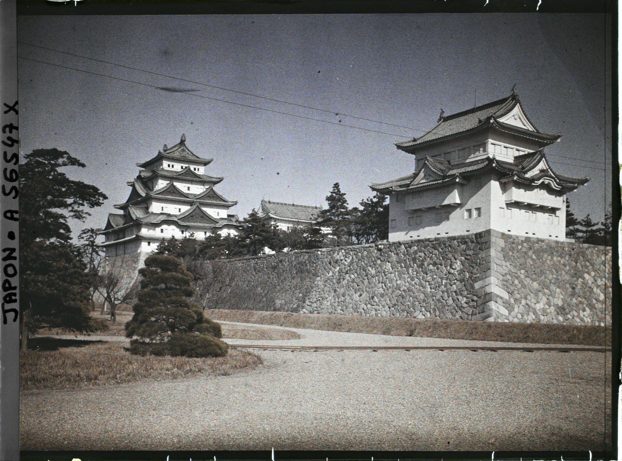 Image représentant Le donjon (tenshu) et une tour d'angle du château de Nagoya (Nagoya-jôshi) depuis le Nishi-no-maru