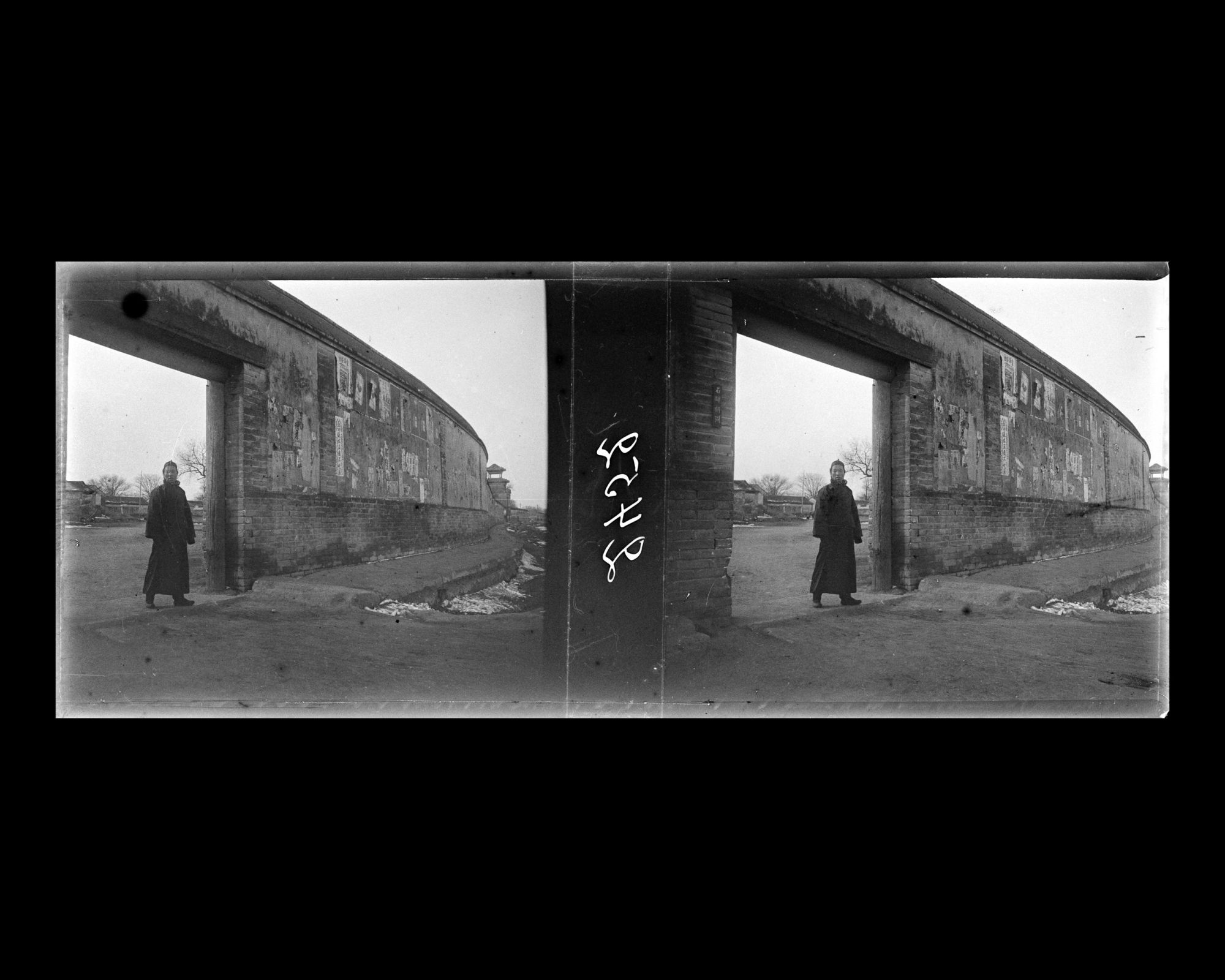 Image représentant Un homme à l'entrée de Shibeihutong ("ruelle de la Stèle de Pierre"), percée dans un mur le long de Xichanganjie ("rue Ouest de la Paix Éternelle")
