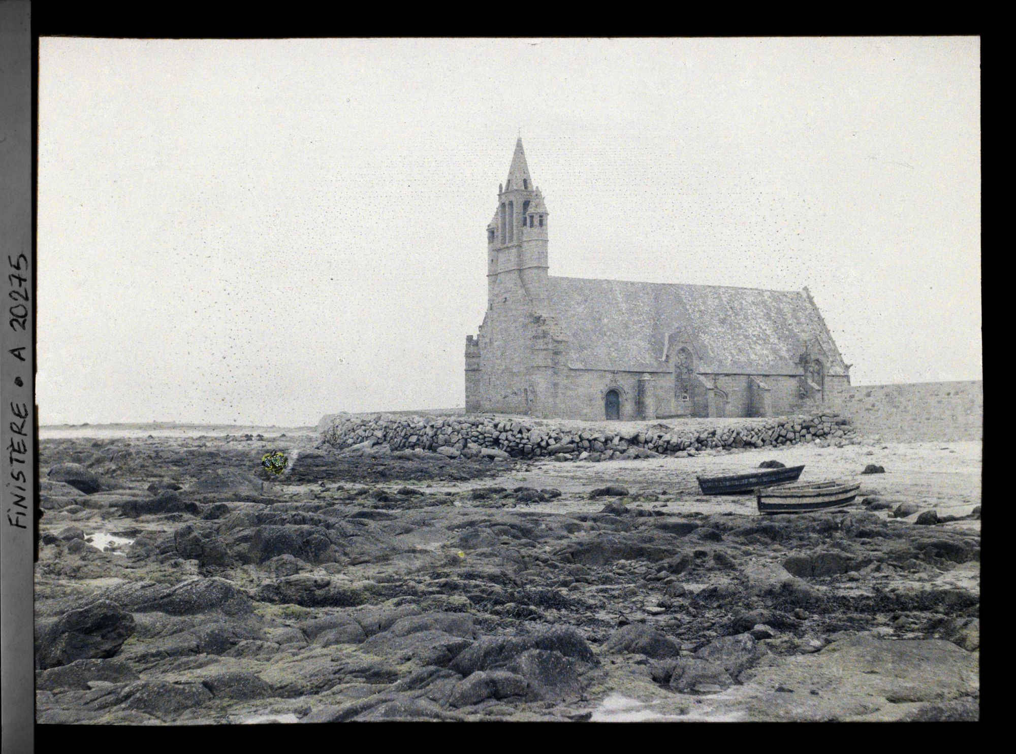 Image représentant La chapelle Notre-Dame-de-la-Joie, des barques échouées sur la grève et les rochers.