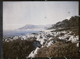 Image représentant La villa Kahn dite villa Zamir, vue depuis le rivage où roches et végétation se mêlent