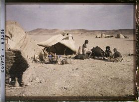 Image représentant Trois hommes  null bishari assis devant leurs habitations