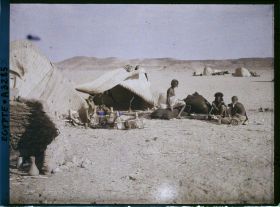 Image représentant Trois hommes  null bishari assis devant leurs habitations