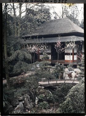 Image représentant Pont et rivière sèche près de la maison ouest du " village japonais " ornée d'arbres en pots fleuris