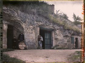 Image représentant Homme, Femme et enfants posant devant une cave troglodyte