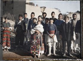 Image représentant Groupe d'hommes, de femmes et d'enfants, au milieu des décombres du village