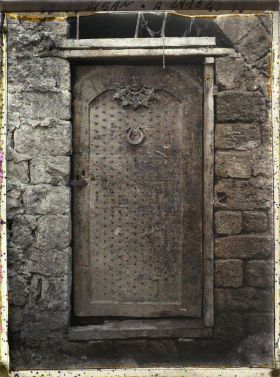 Image représentant Porte ancienne de bois clouté dans une cour d'église