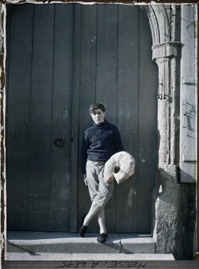 Image représentant Le jeune Robert Baudier, posant devant la boulangerie familiale avec la miche du pays