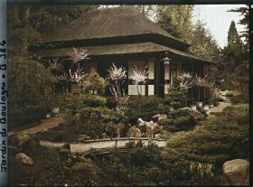 Image représentant Pont et rivière sèche près de la maison ouest du " village japonais " ornée d'arbres en pots fleuris