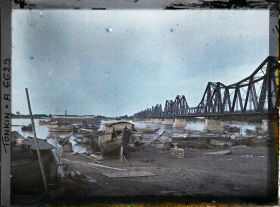 Image représentant Des sampans sur les quais du Fleuve Rouge, près du pont Doumer, au coucher du soleil