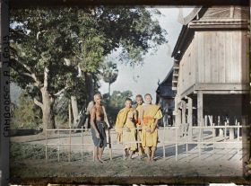 Image représentant Des bonzes près des édifices sur pilotis de la bonzerie