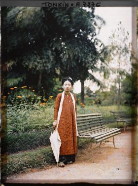 Image représentant Une jeune femme de classe aisée, tenant une ombrelle blanche dans un jardin public