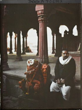 Image représentant Fidèle près de la statue de Ganesh couverte d'offrandes dans le temple de Vishvesvara