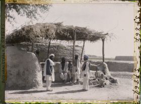 Image représentant Hommes en discussion sous un auvent de maison de thé